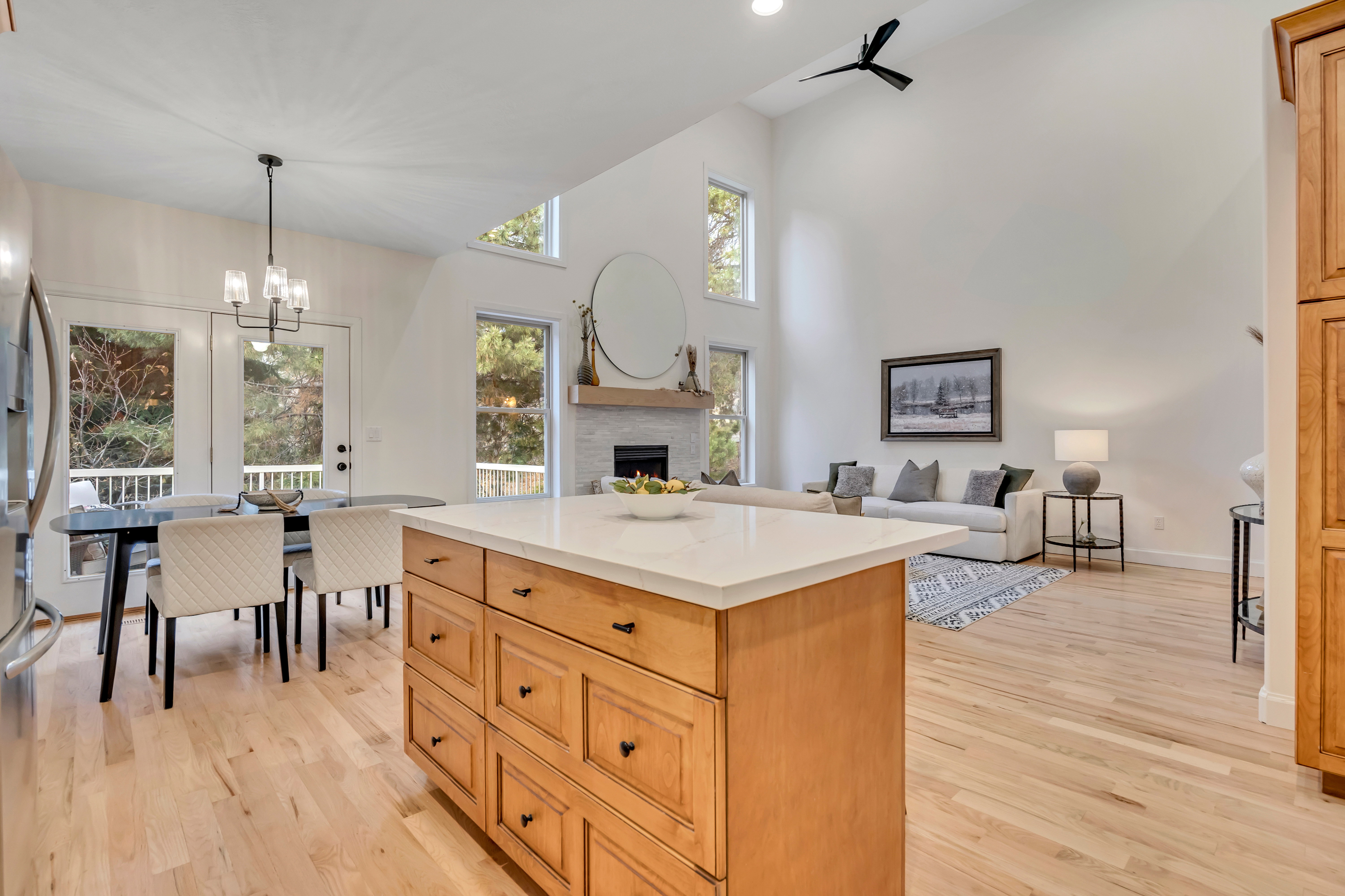 Open-concept living space featuring a central kitchen island with wood cabinetry and a light-colored countertop