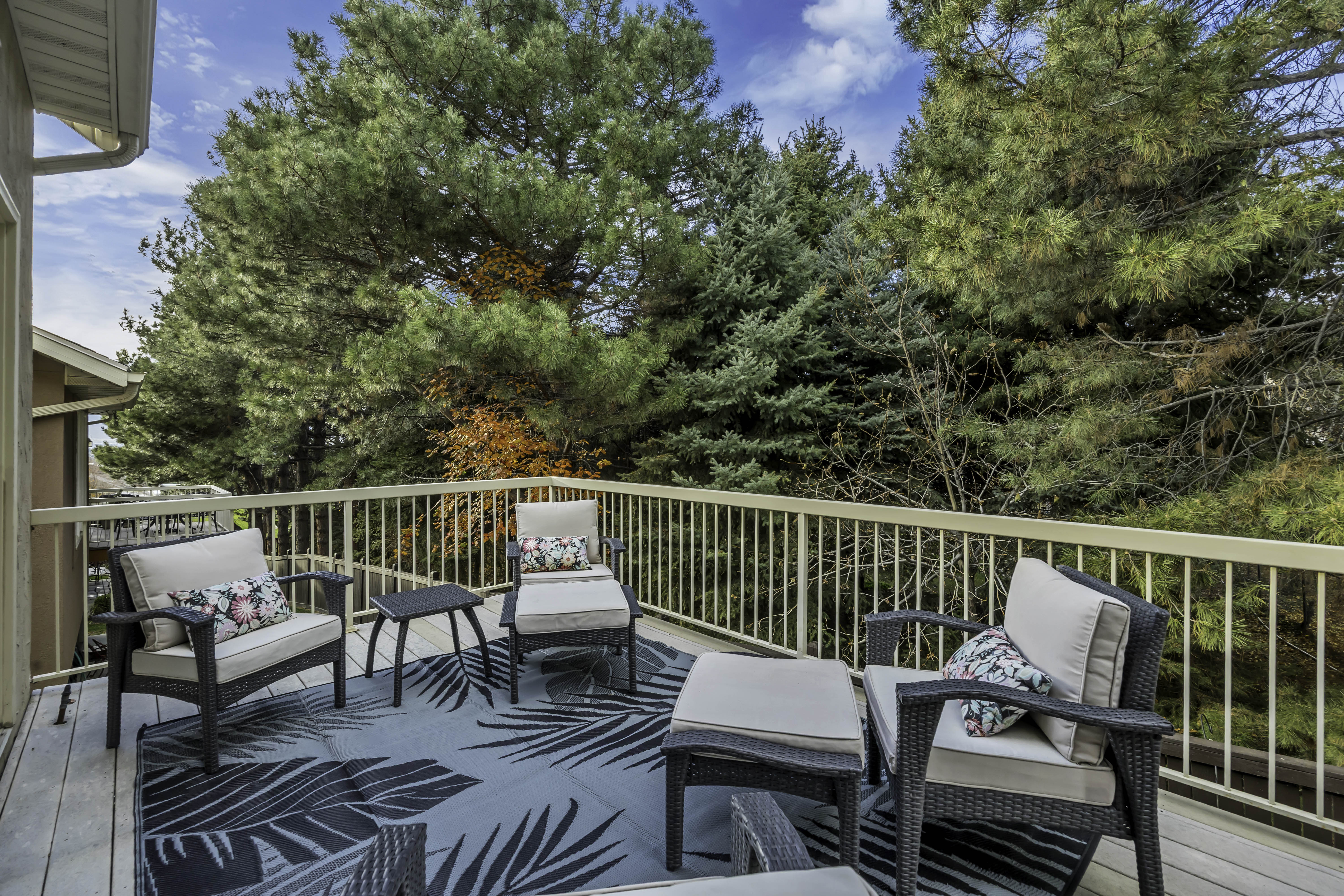 Expansive outdoor deck with wood-finish flooring and a white railing system