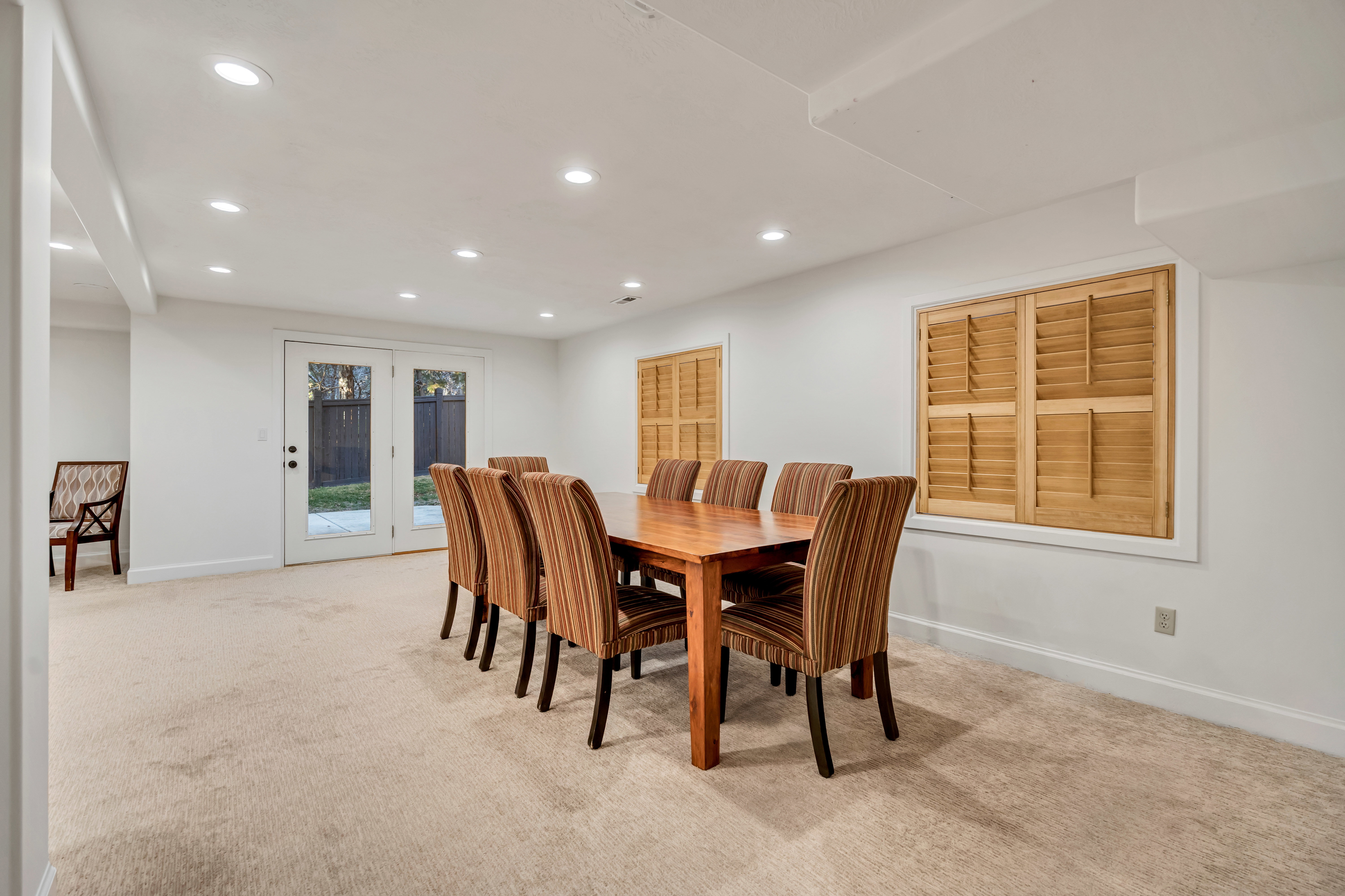 Carpeted room with recessed lighting and double glass-paneled doors