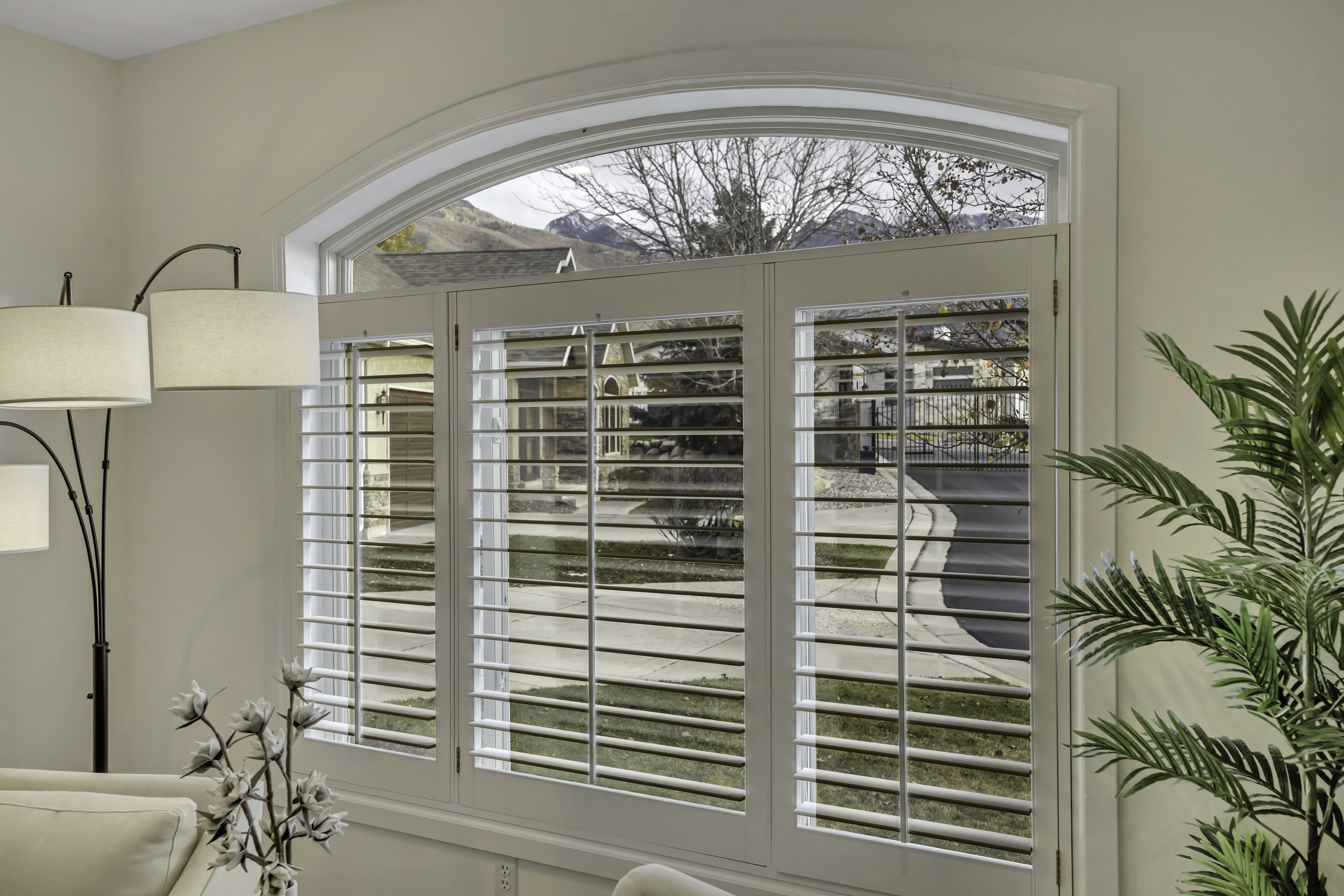 Arched window with custom plantation shutters