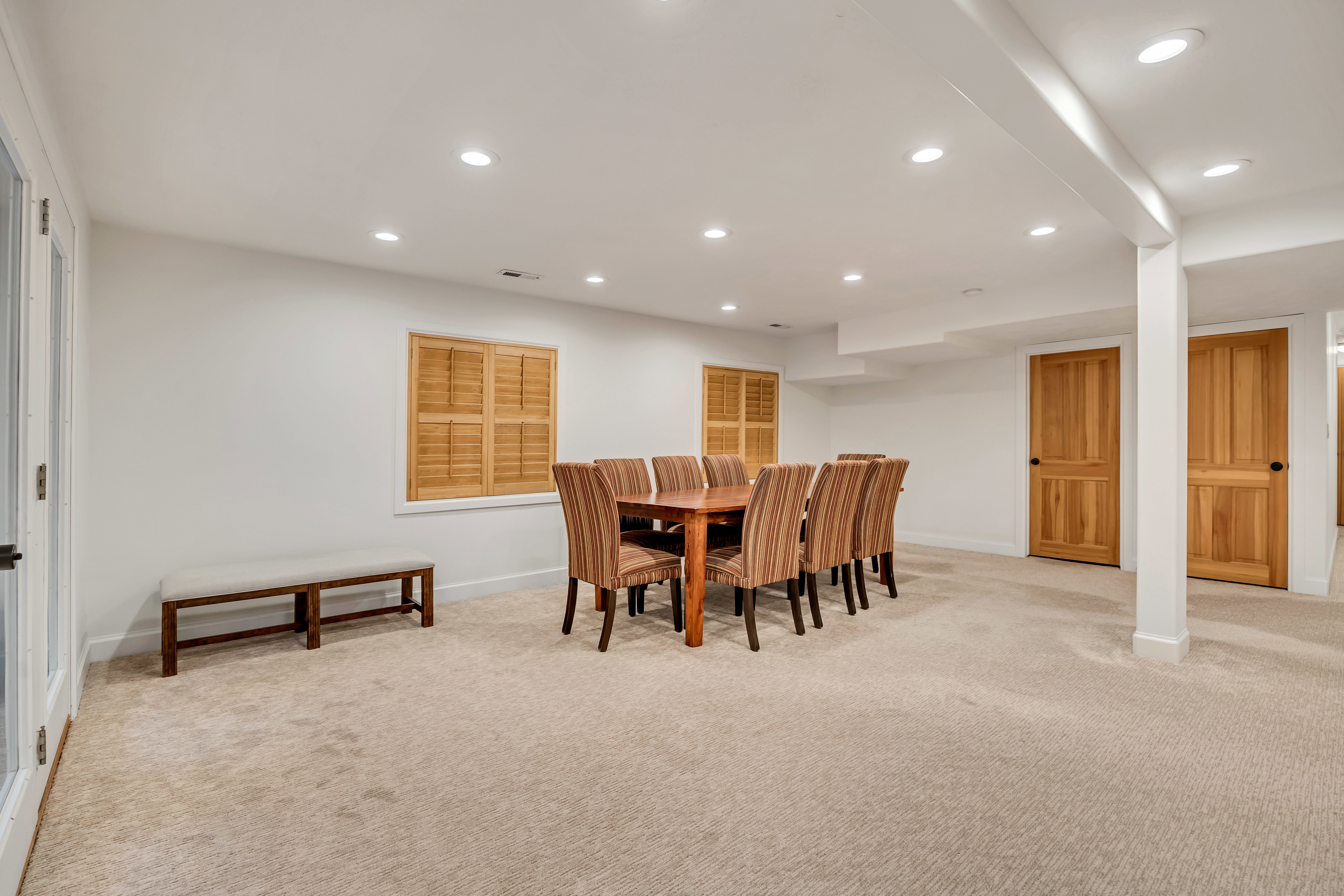 Spacious room featuring neutral carpeting, recessed lighting, and white walls