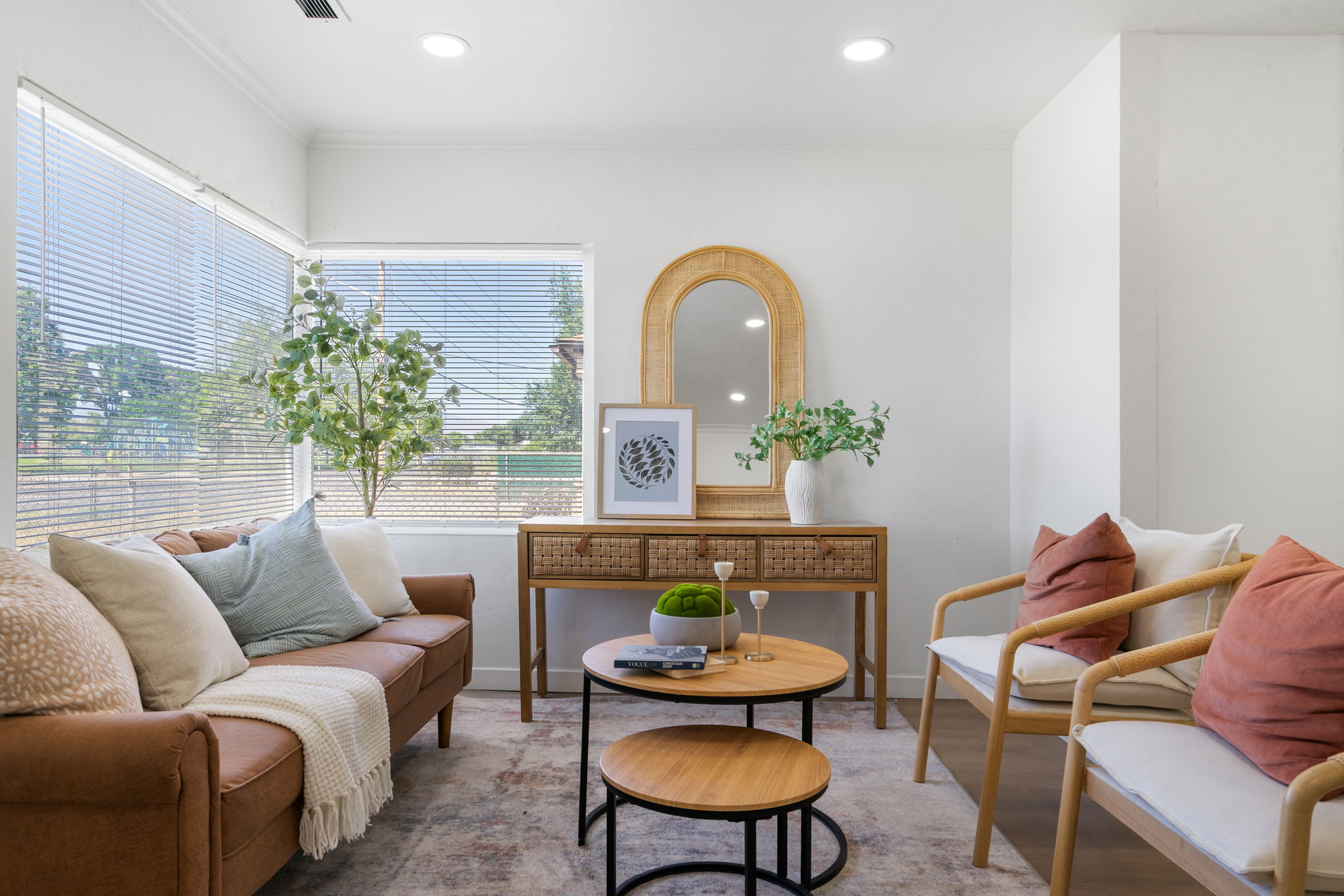 Spacious living area featuring expansive windows with horizontal blinds, recessed lighting, wood-finish flooring, and a neutral color palette