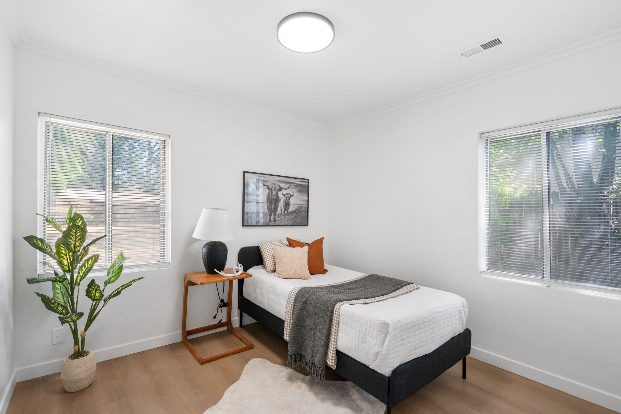 Bedroom featuring wood-finish flooring, white walls, and bright white trim