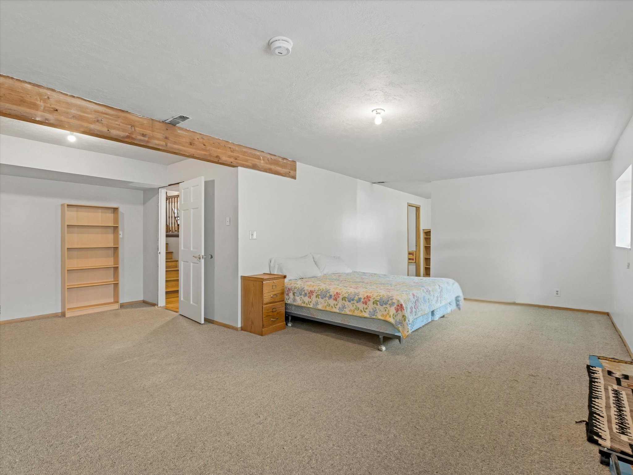 Spacious room featuring neutral carpeting and white walls