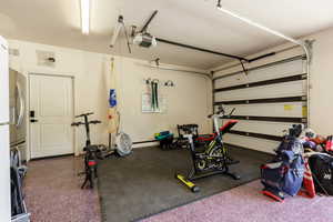 Attached garage featuring an epoxy-coated floor, painted walls, and a white paneled overhead door