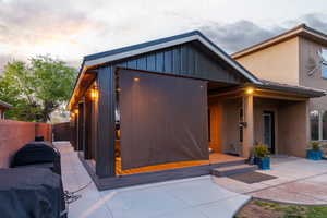 Rear exterior with a covered patio and attached sunroom featuring a gabled roofline