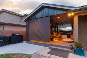 Covered patio with recessed lighting, wood-finish decking, and retractable screens