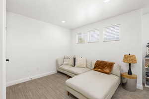 Bright white walls complement recessed lighting and a neutral-toned carpet