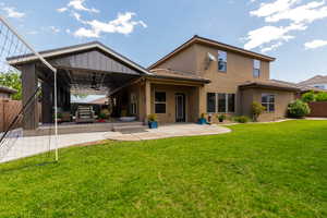 Expansive backyard featuring a covered patio, concrete patio, and a manicured lawn