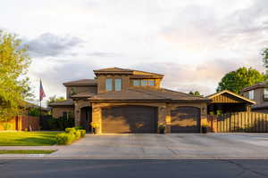 Two-story stucco residence featuring a tile roof and integrated two-car garage