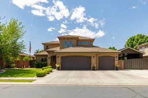 Stucco exterior residence featuring a stone accent wall, tile roofing, and an integrated three-car garage