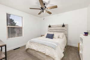 Bright room featuring a window with blinds, a ceiling fan with light fixture, light gray carpeting, and a built-in headboard with integrated sconces