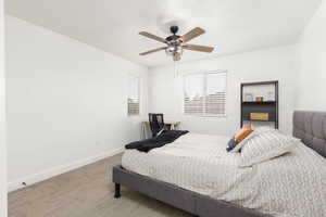 Bright room featuring a ceiling fan with light fixture, two windows with horizontal blinds, and neutral carpeting