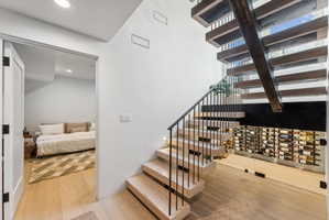 Modern open-riser staircase with wood treads and a black metal railing