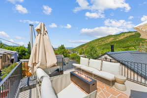 Rooftop deck featuring composite decking, black metal railings, and a built-in linear fire pit