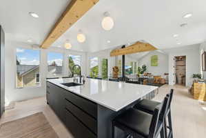 Modern kitchen island featuring a white countertop, undermount sink with a matte black faucet, and seating for two