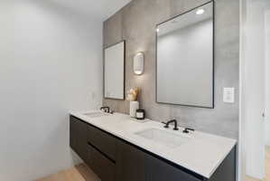 Floating double vanity with integrated sinks, white countertops, matte black faucets, and rectangular mirrors