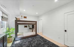 Spacious room featuring light wood-finish flooring and recessed lighting