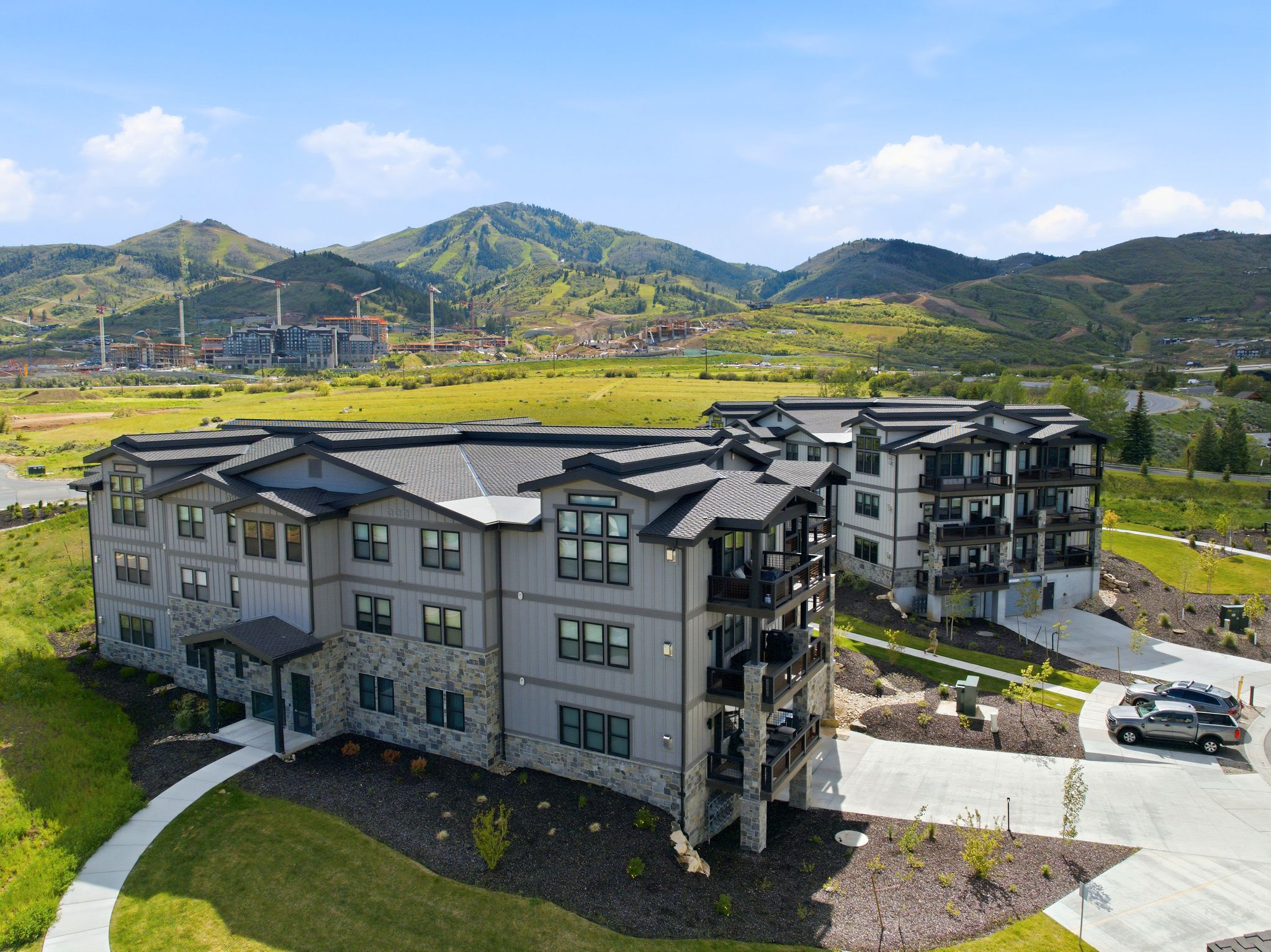 Contemporary multi-story buildings featuring stone accents, dark-framed windows, and private balconies