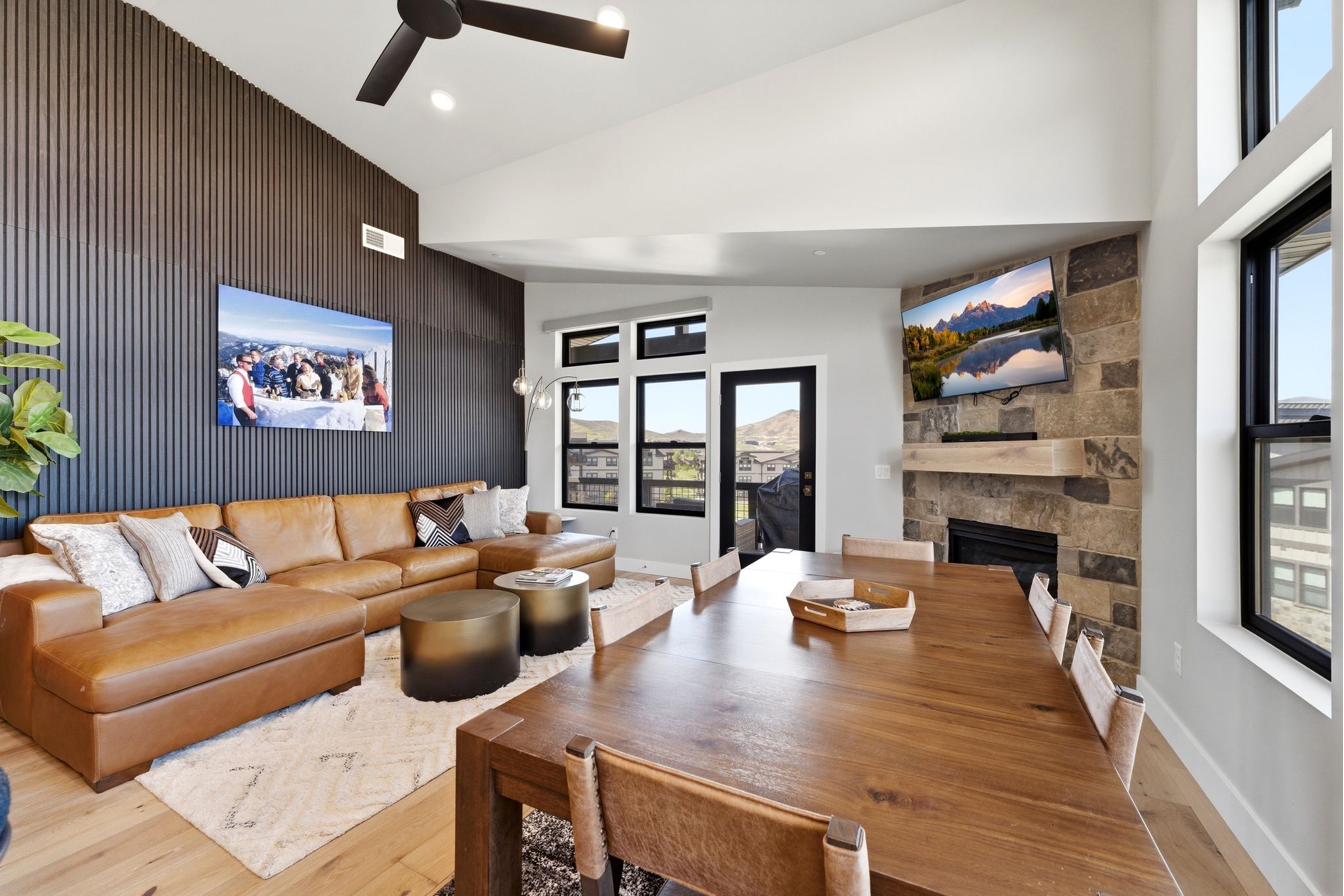 Open-concept living area with a vaulted ceiling and exposed beam