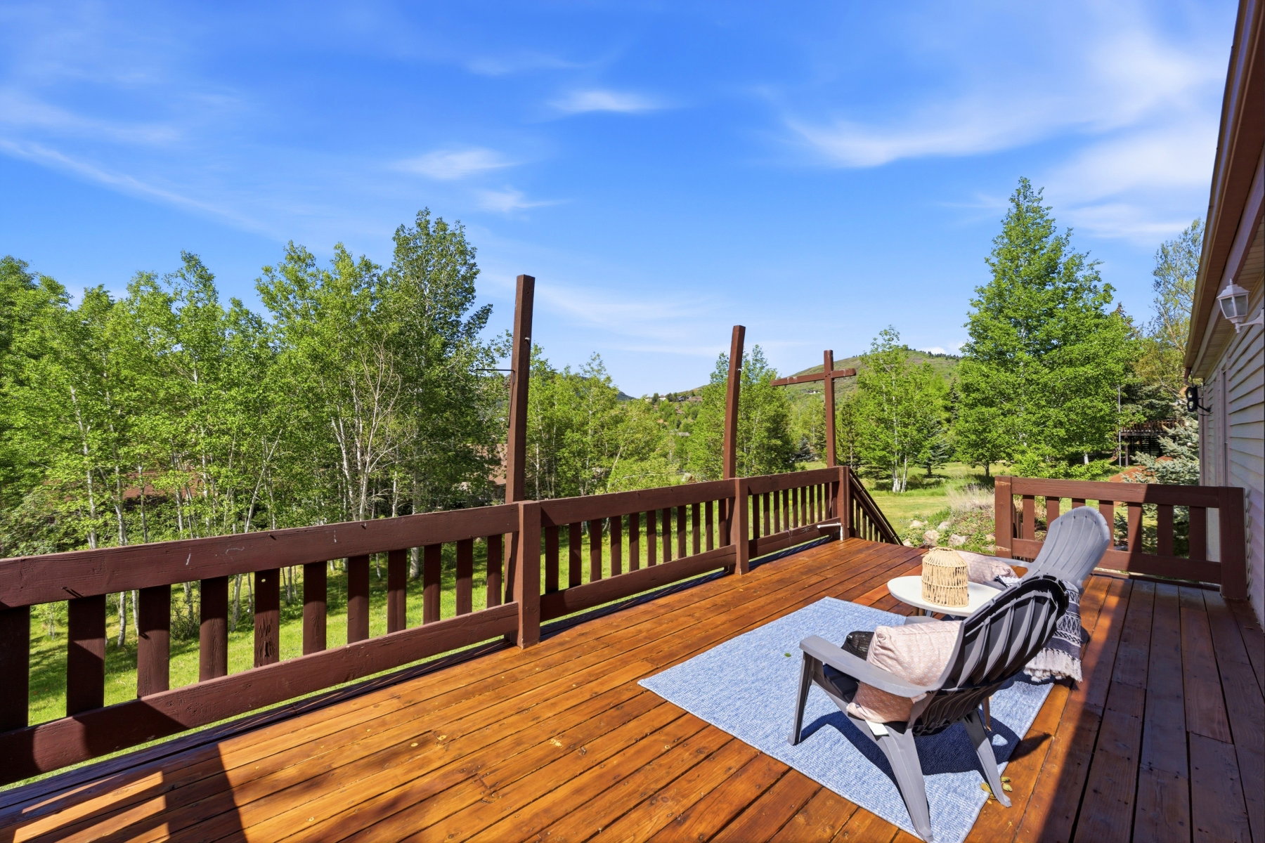 Spacious outdoor deck with rich wood flooring and a sturdy wood railing