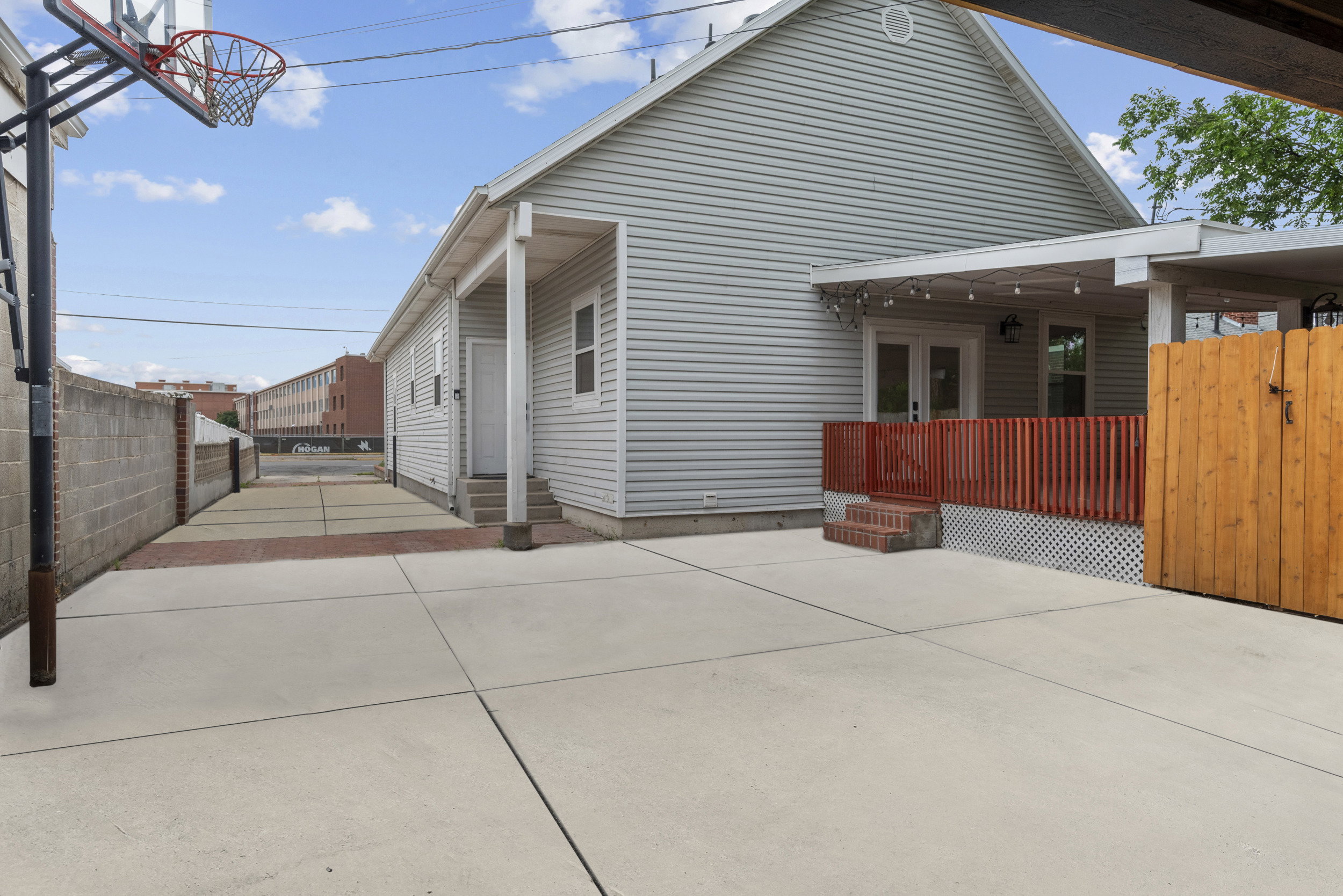 Spacious concrete patio with an attached covered porch and string lighting
