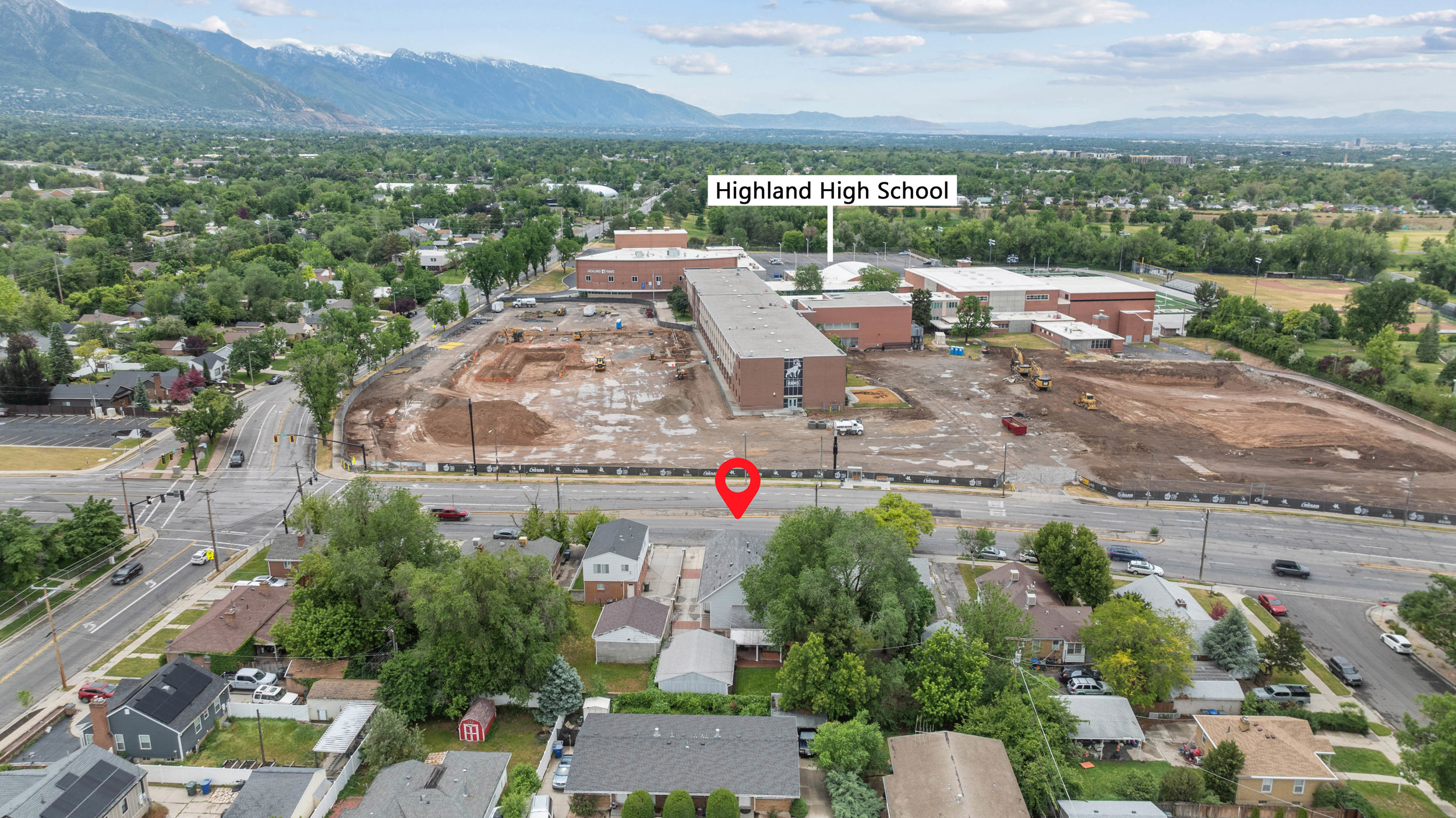 Aerial perspective showcasing a residential area with established trees and surrounding infrastructure