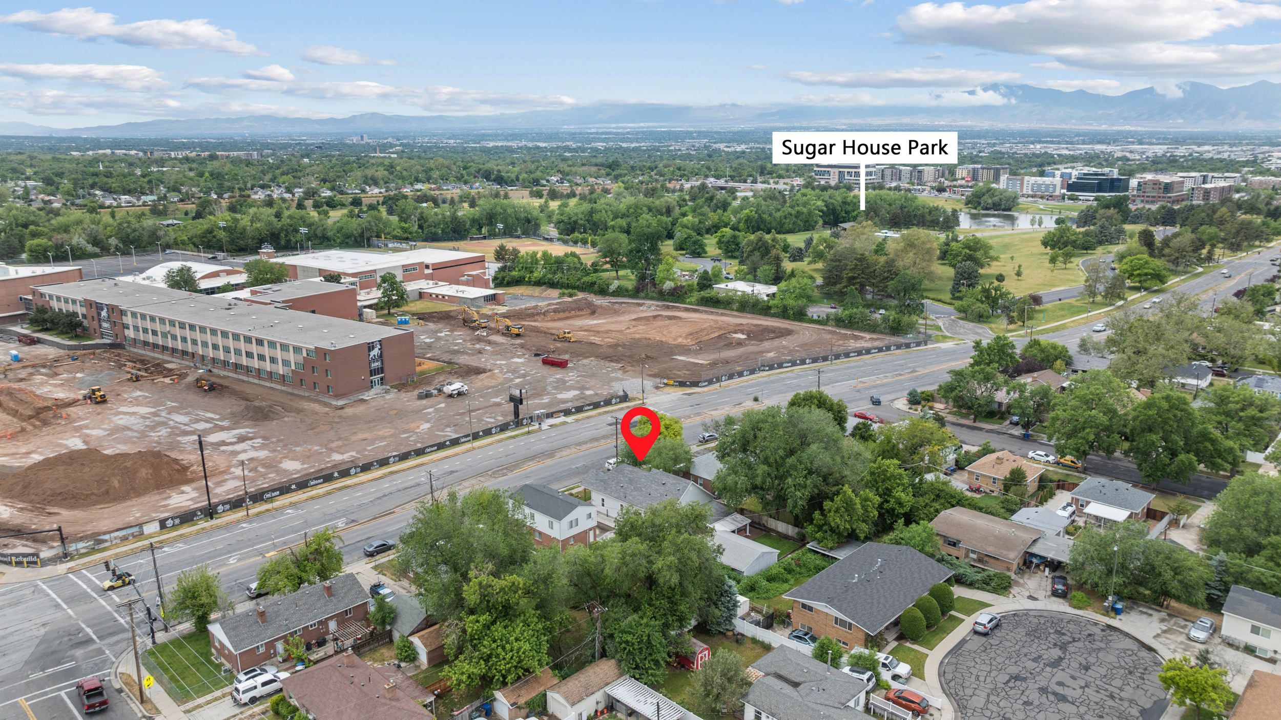 Aerial perspective showcasing the property's setting amidst residential homes, mature trees, and urban infrastructure
