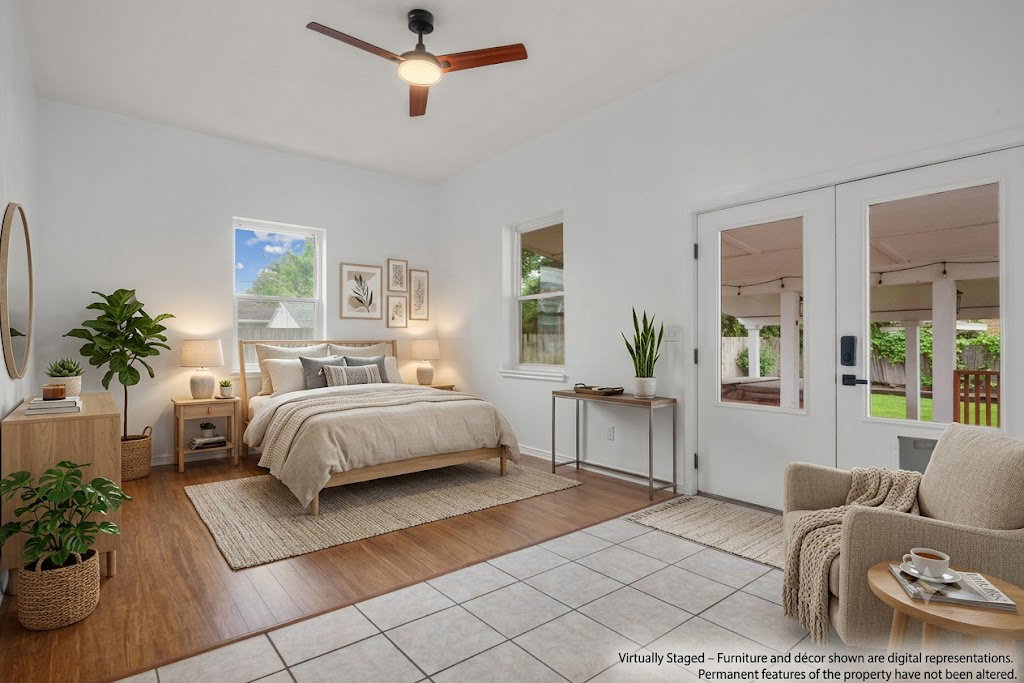 AI staged bedroom featuring a ceiling fan, wood-finish flooring, two windows, and French doors opening to an outdoor area