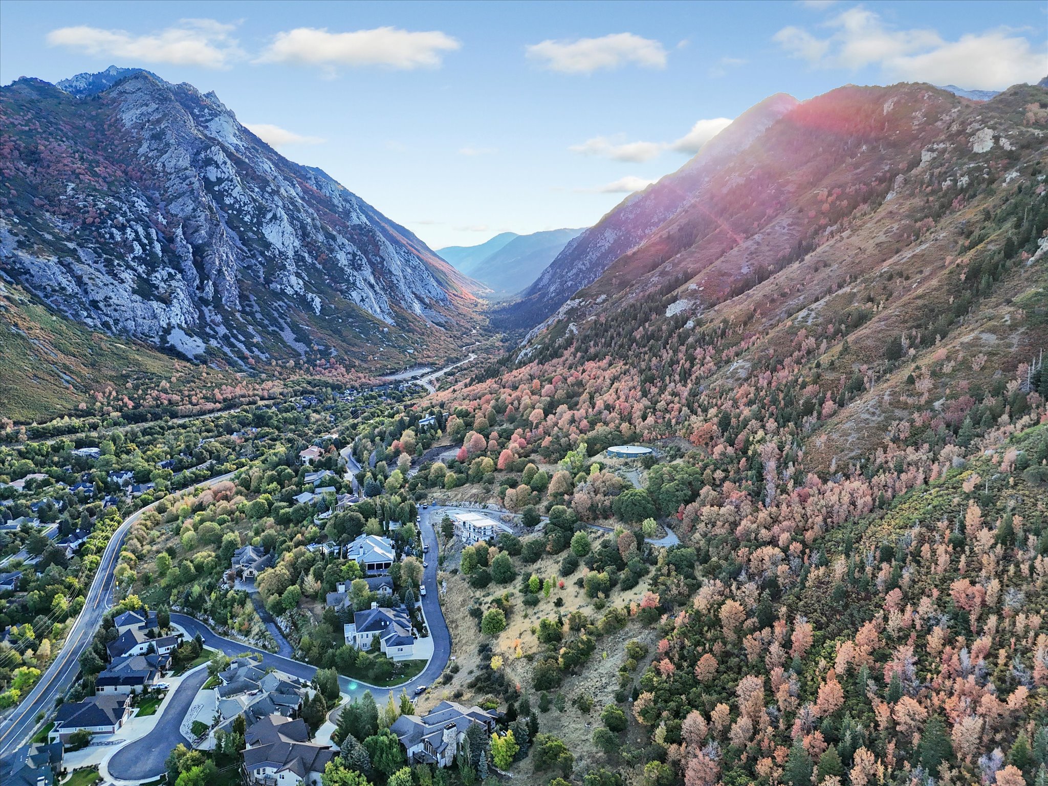Aerial perspective showcasing a mountain valley setting with winding roads and residential properties