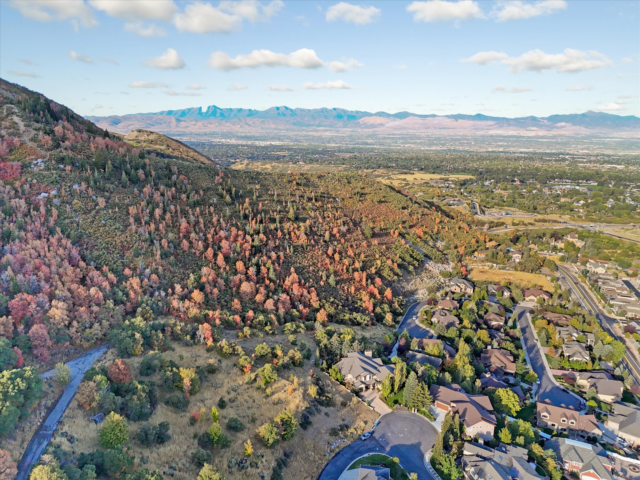 Expansive aerial showcasing a mountainous landscape with vibrant autumn foliage