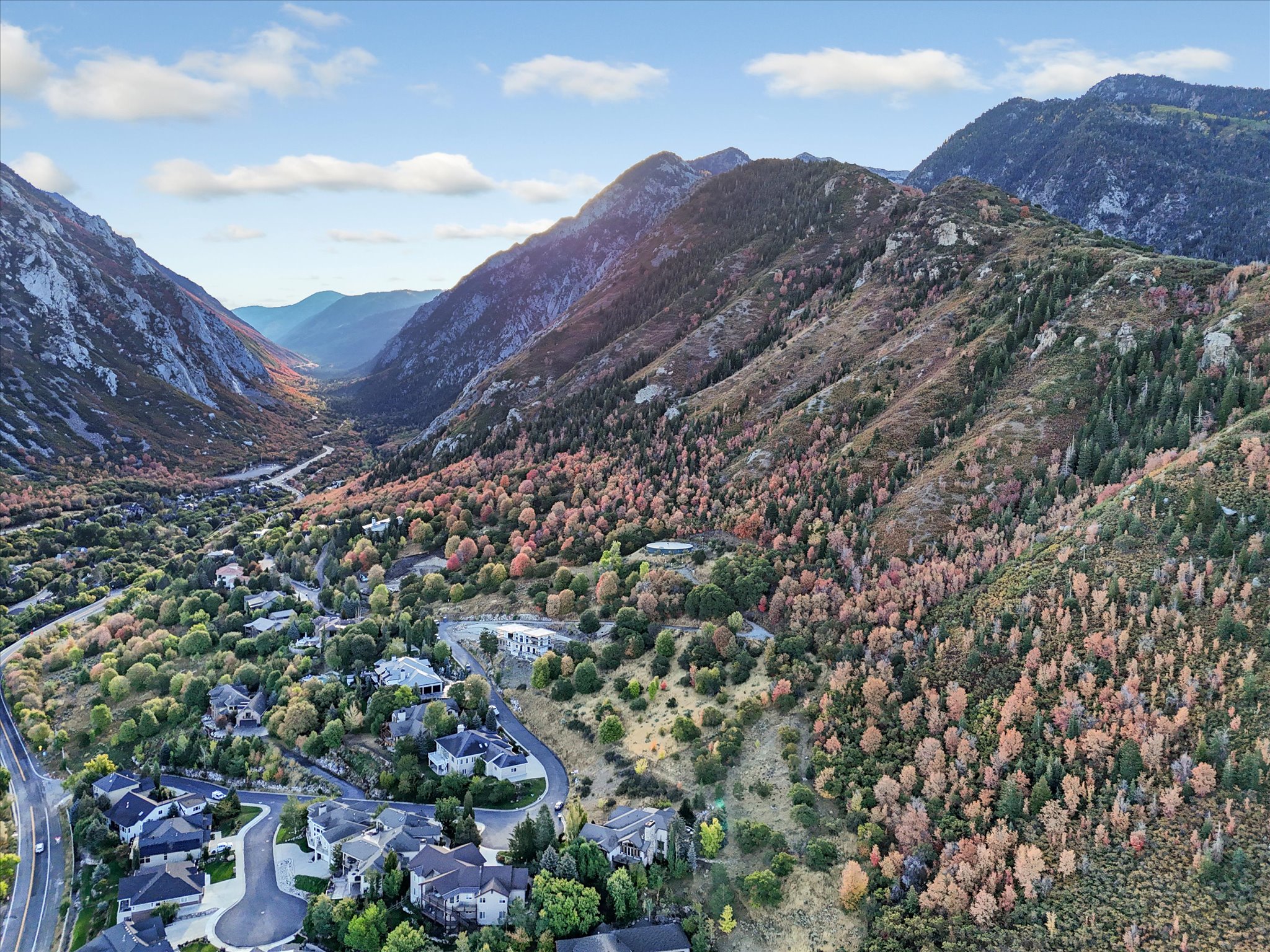 Valley landscape featuring a mountainous backdrop, extensive tree coverage, and a residential community
