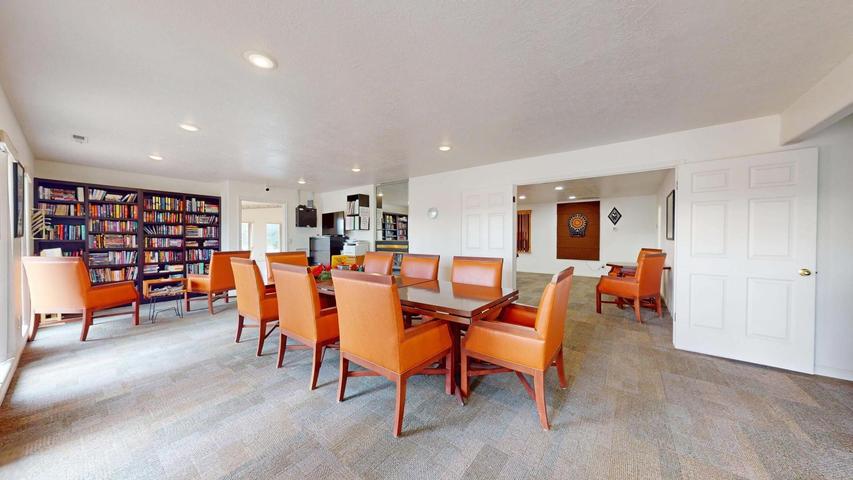 Spacious common area featuring textured carpet flooring, recessed lighting, and white walls