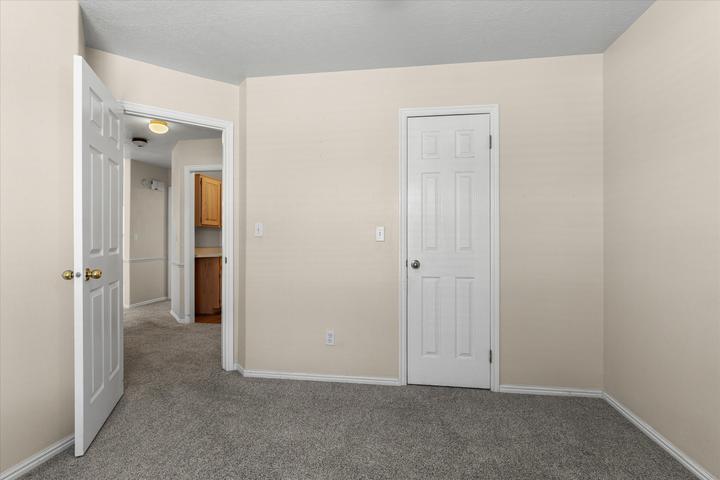 Neutral tone wall paint with crisp white baseboards and gray carpet flooring