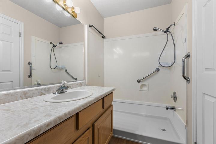 Bathroom featuring a vanity with a laminate countertop, an undermount sink, and wood-finish cabinetry