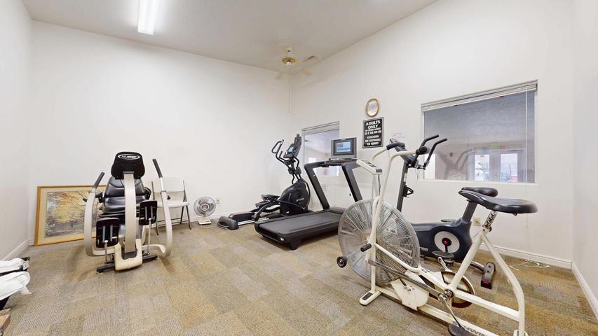 Dedicated fitness room featuring recessed lighting, a ceiling fan, and two windows with blinds