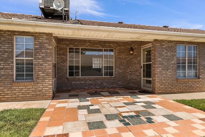 Brick exterior featuring a tiled patio