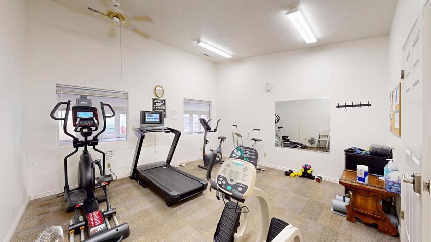Fitness room with carpet flooring and white walls