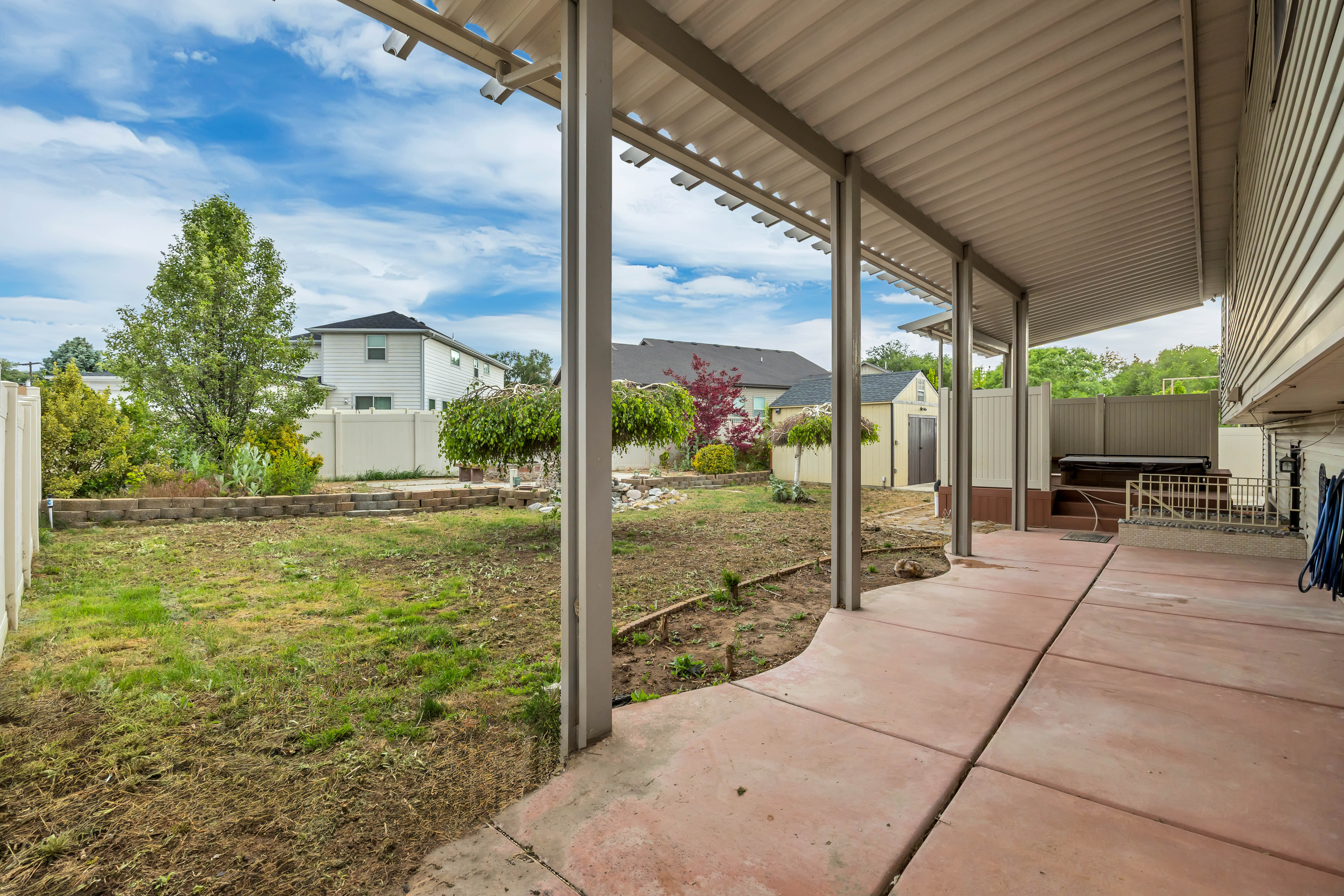 Expansive covered patio featuring a concrete slab and metal support beams
