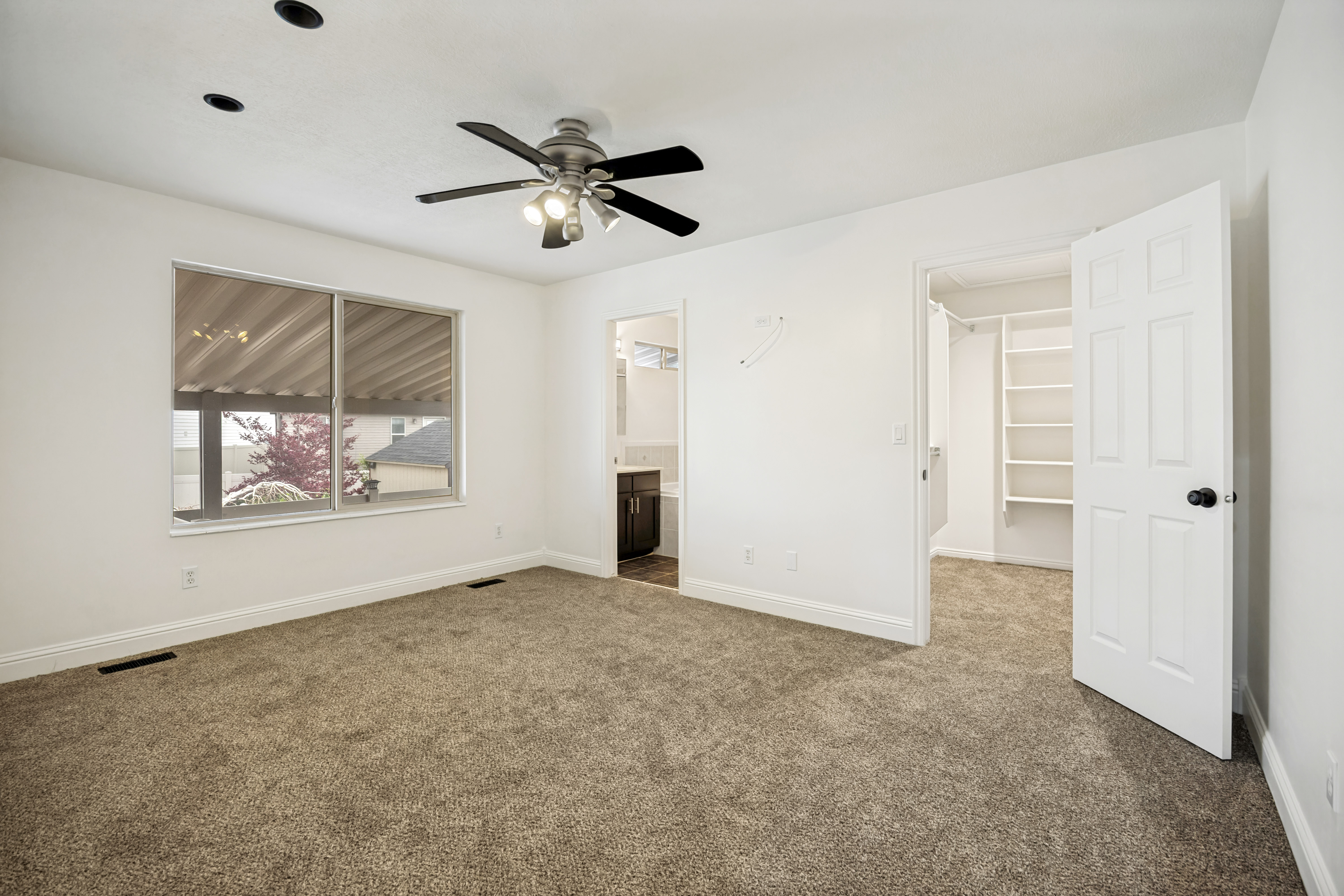 Spacious room featuring neutral carpeting and white walls
