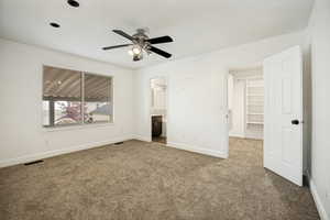 Spacious room featuring neutral carpeting and white walls
