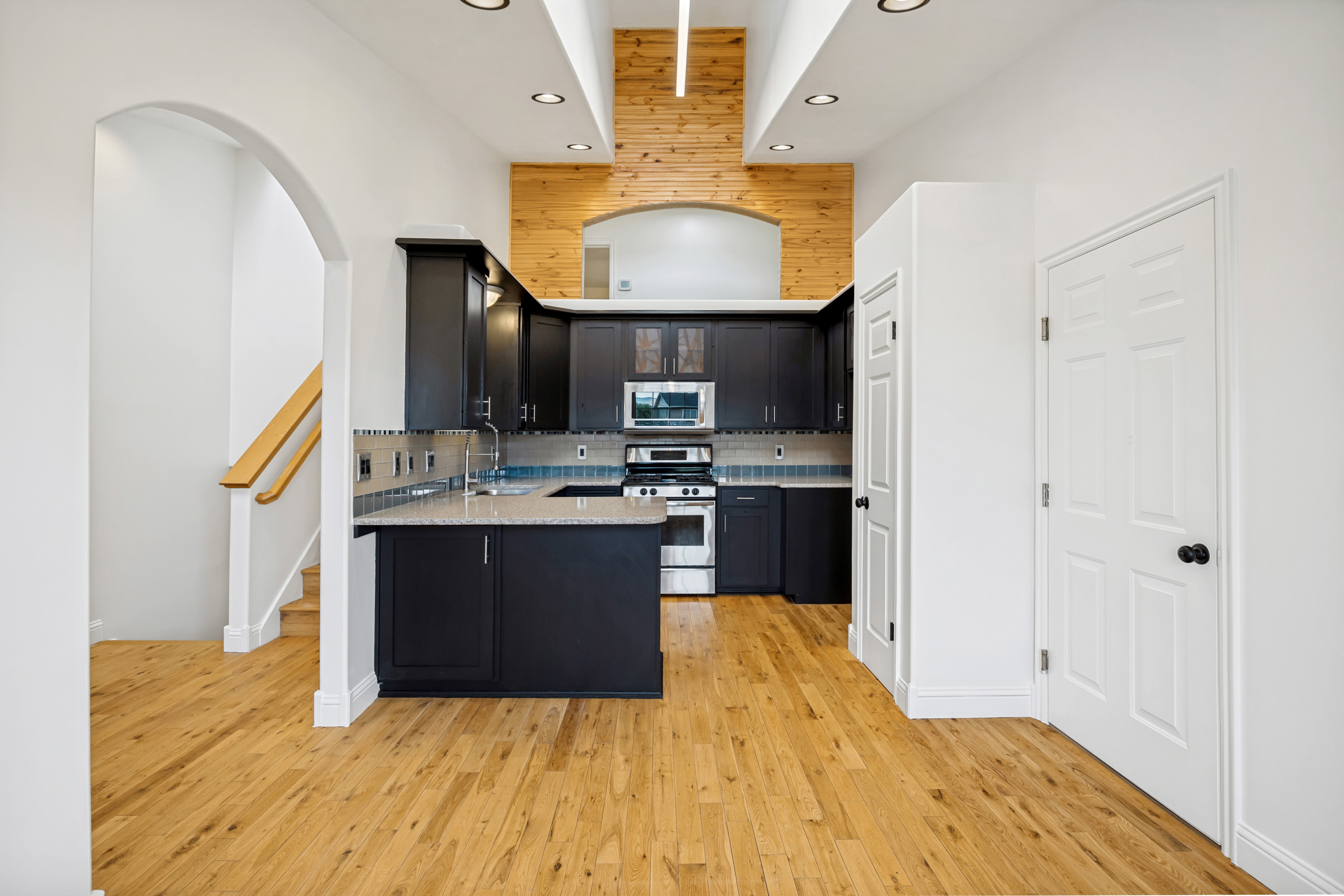Kitchen featuring dark cabinetry, light-toned countertops, a full suite of stainless steel appliances, and a mosaic tile backsplash