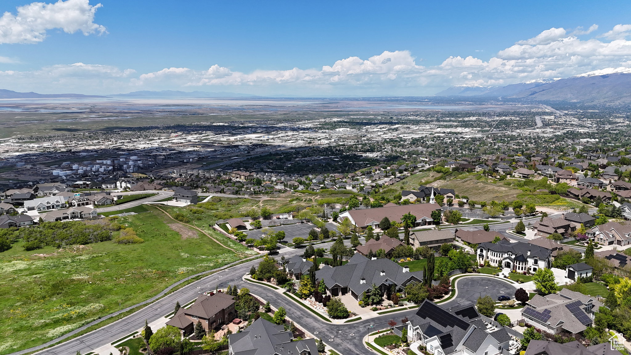 Expansive aerial showcasing a residential area with varied architectural styles under a bright blue sky