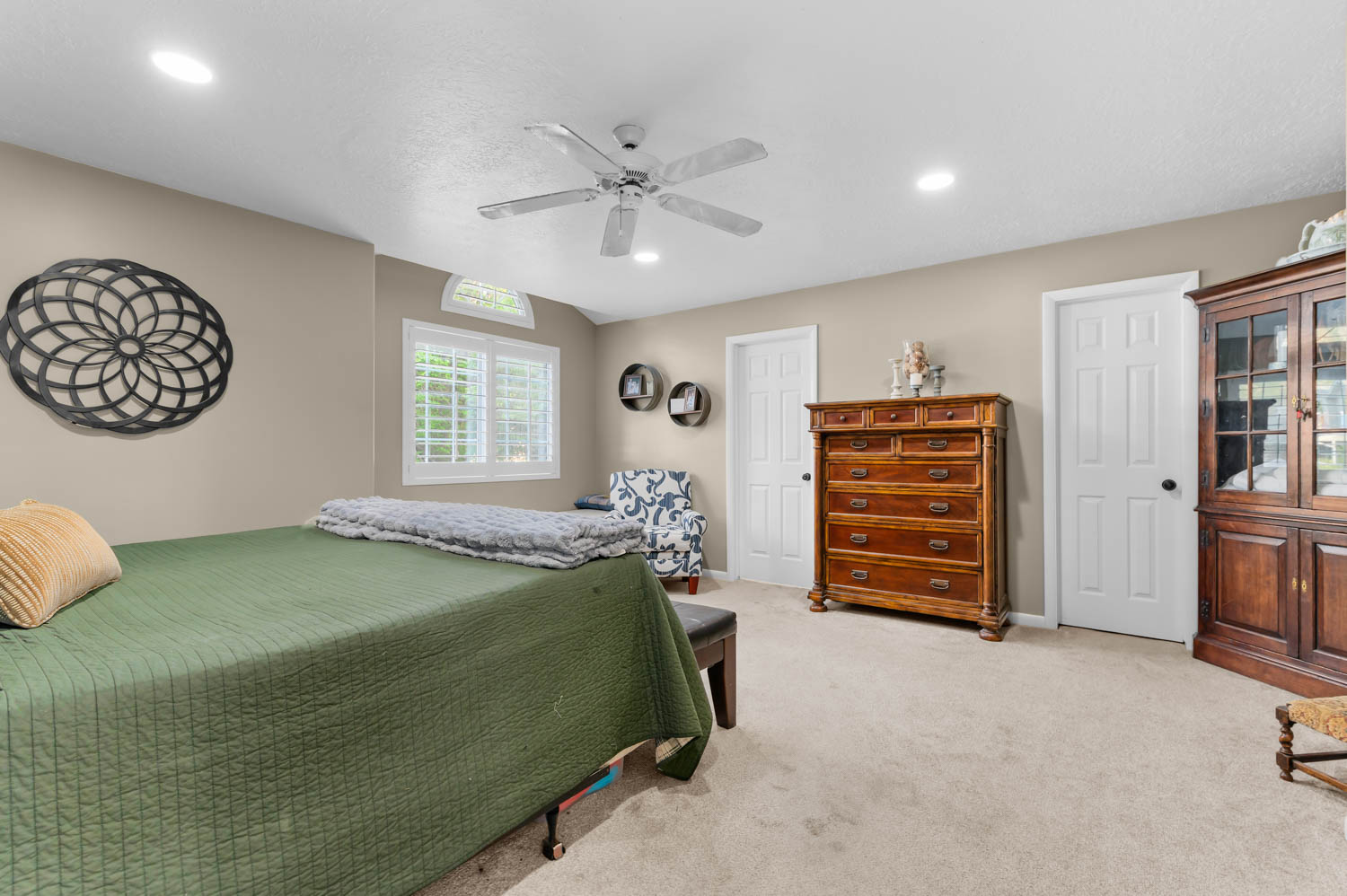 Carpeted room featuring a ceiling fan with integrated lighting, recessed lighting, and a window with plantation shutters