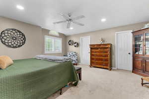 Carpeted room featuring a ceiling fan with integrated lighting, recessed lighting, and a window with plantation shutters