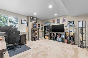 Carpeted interior space featuring a window with blinds, recessed lighting