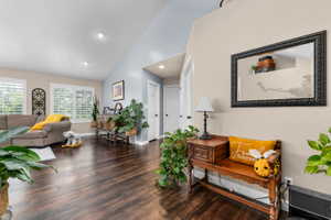 Spacious living area featuring wood-finish flooring, vaulted ceilings, and recessed lighting