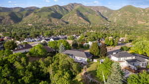 Residential neighborhood situated against a backdrop of mountains and surrounded by abundant mature trees