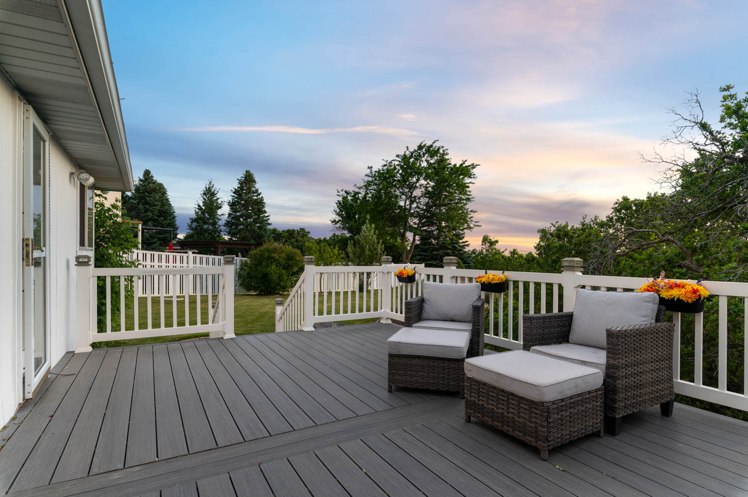 Spacious outdoor deck featuring composite decking, white railing, and a secure gate