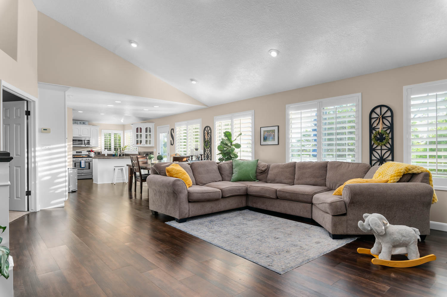 Vaulted ceilings and dark wood-finish flooring define this open-concept living space